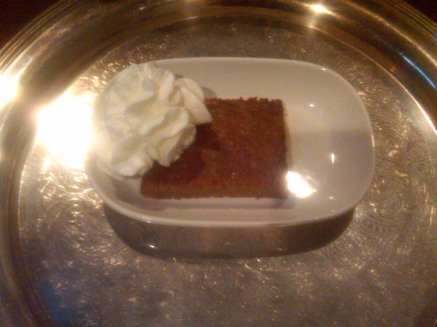 /home/wpcom/public_html/wp-content/blogs.dir/3e6/17878083/files/2011/11/persimmon-pudding.jpg Slice of traditional persimmon pudding with whipped cream